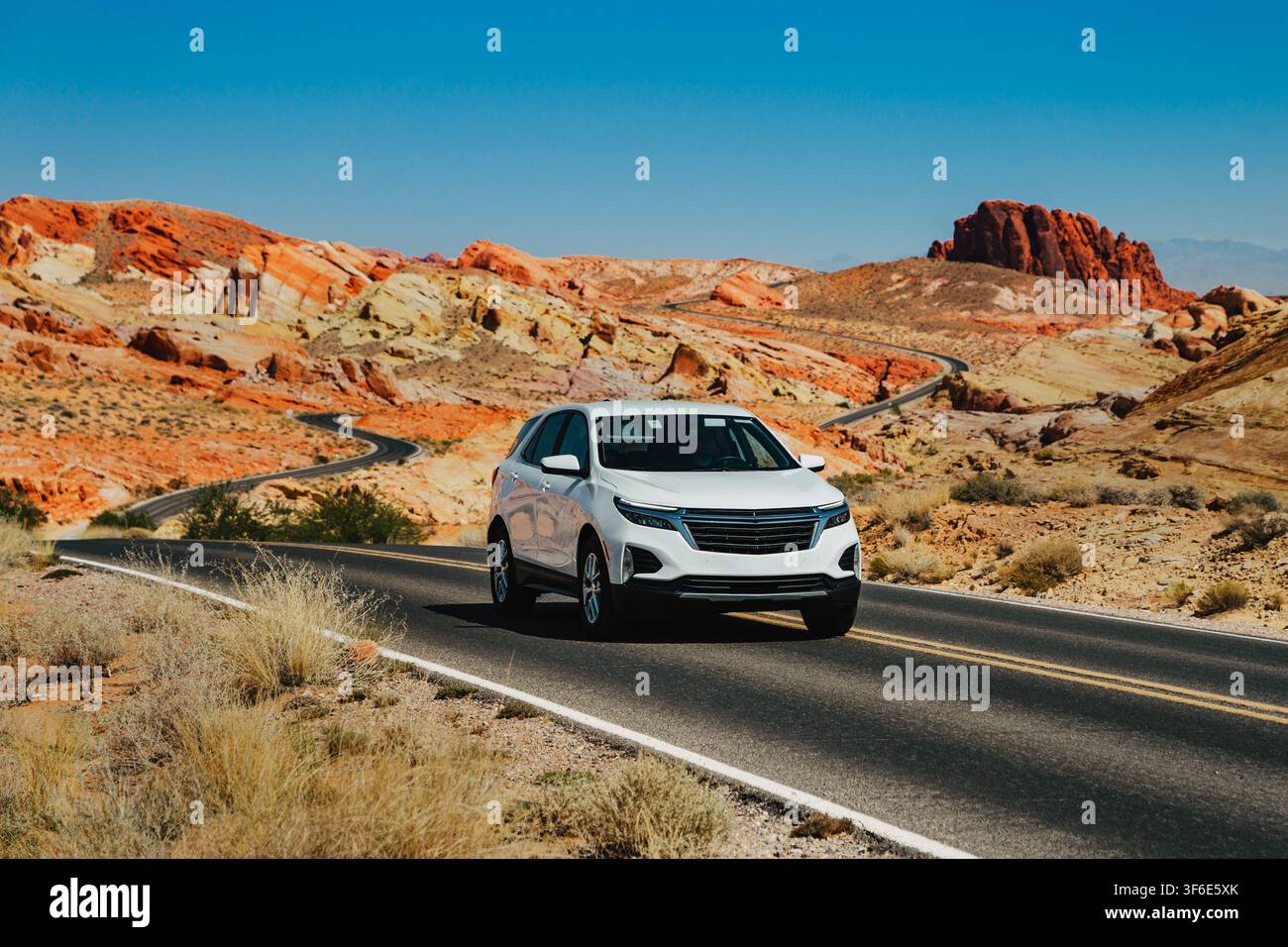 VALLEY OF FIRE, USA - SEPTEMBRE 2024 : VUS moderne blanc roulant sur une route asphaltée sinueuse entourée de formations rocheuses en grès rouge dans le Valley of Fire S Banque D'Images