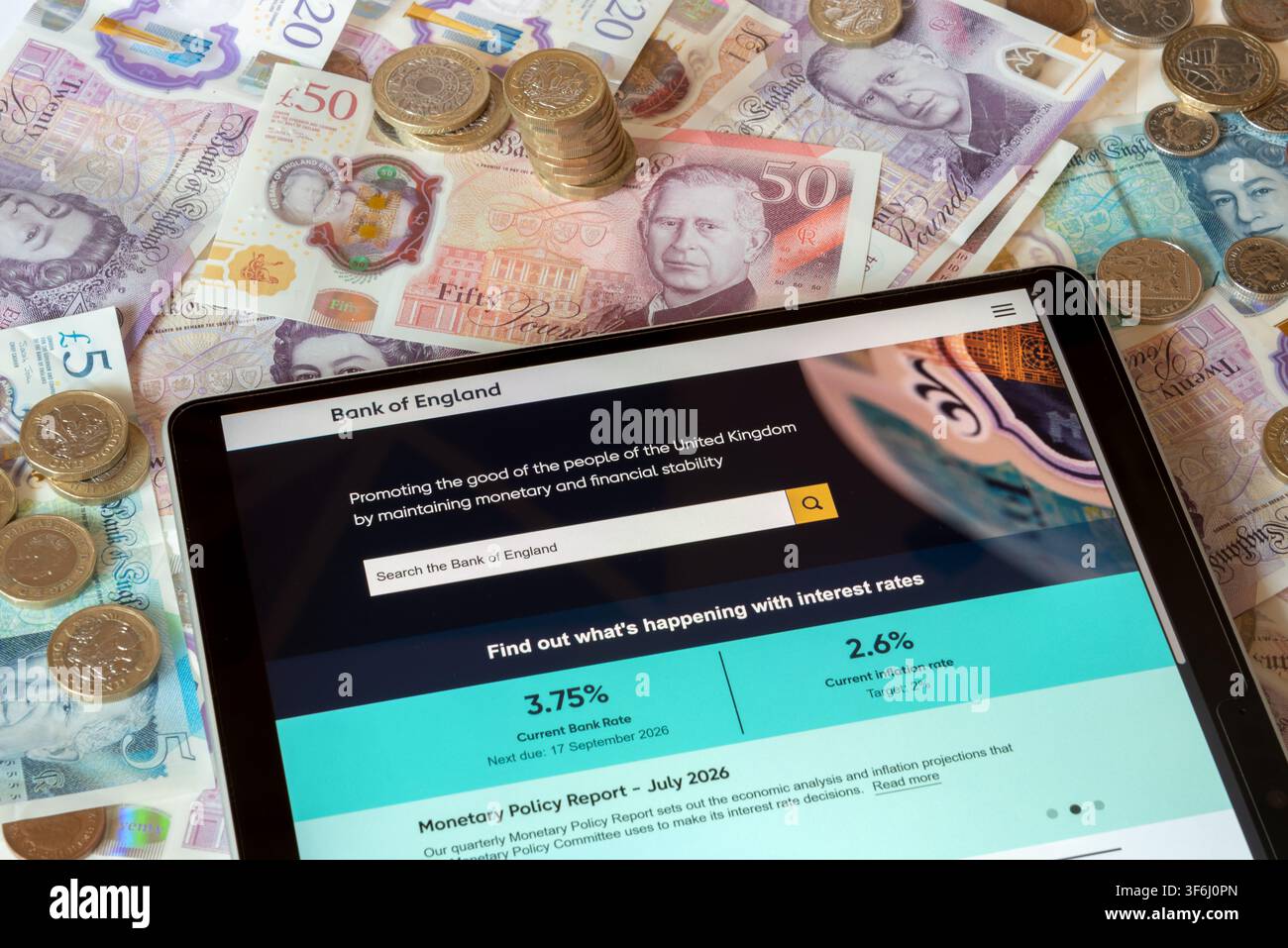 Site web de la BoE Bank of England avec des billets et pièces en livres sterling en arrière-plan Banque D'Images