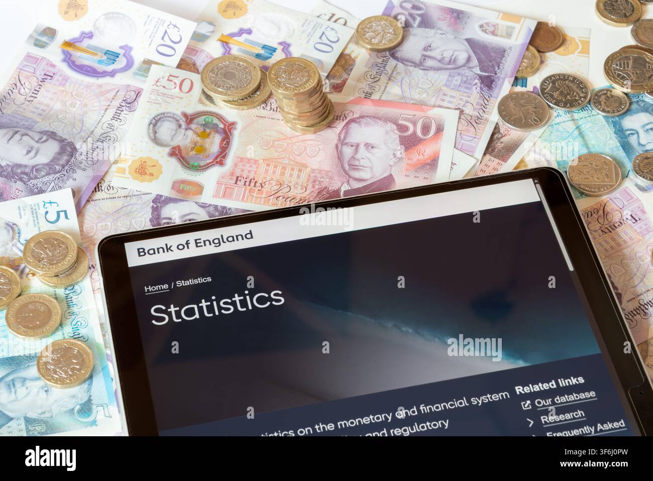 Site web de la BoE Bank of England avec des billets et pièces en livres sterling en arrière-plan Banque D'Images