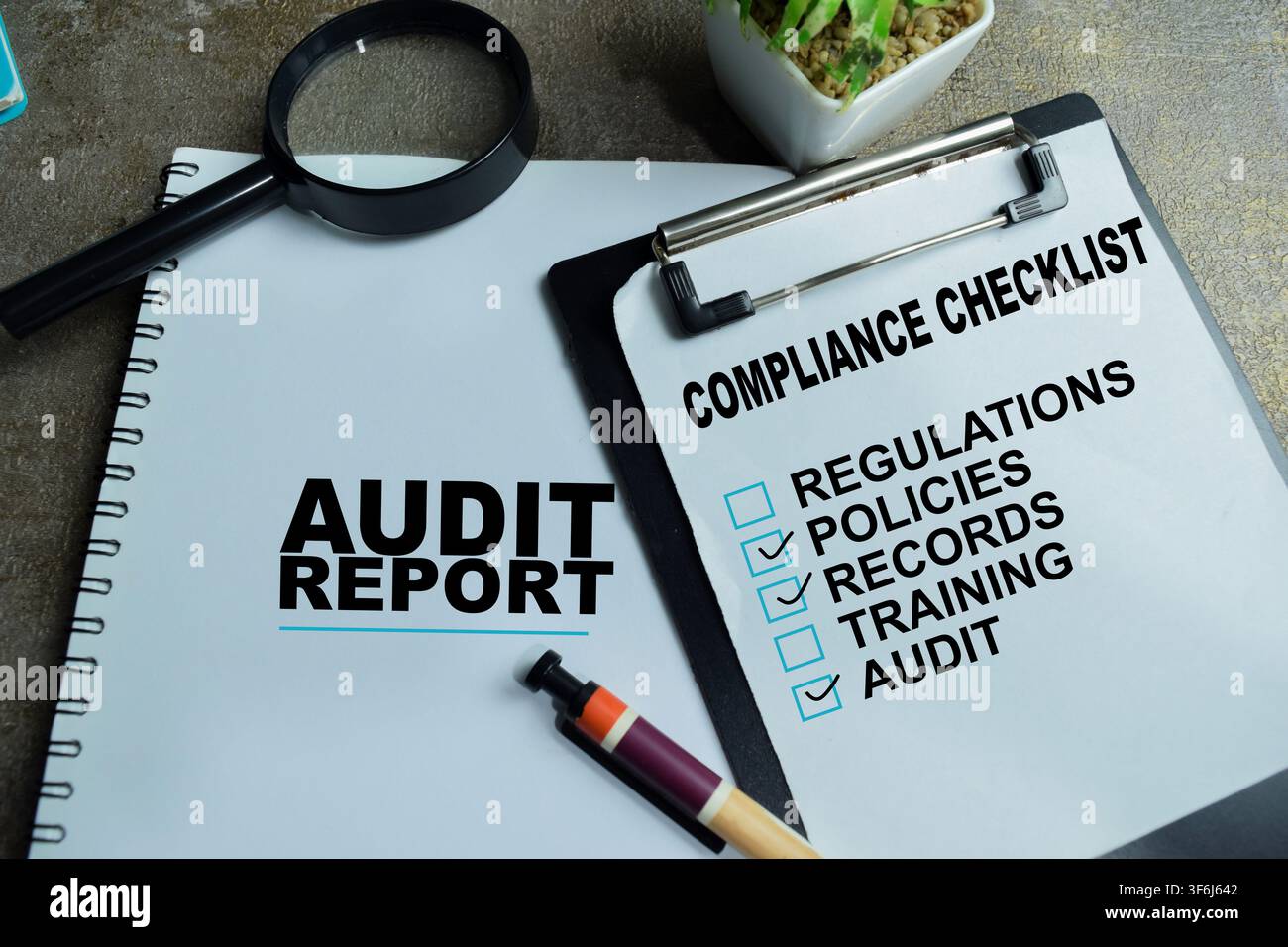 Concept d'audit et de conformité écrit sur un tableau avec un rapport d'affaires, liste de contrôle isolée sur une table en bois. Banque D'Images