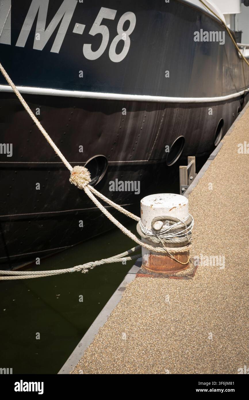 Câbles attachés à une bitte d'amarrage sur le quai. Banque D'Images