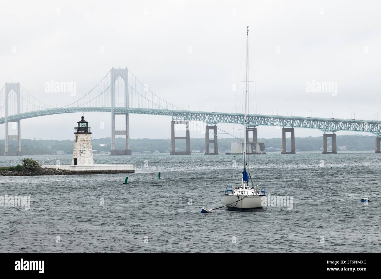 Phare de Goat Island, Newport, Rhode Island, avec un voilier et le pont Claiborne en arrière-plan Banque D'Images