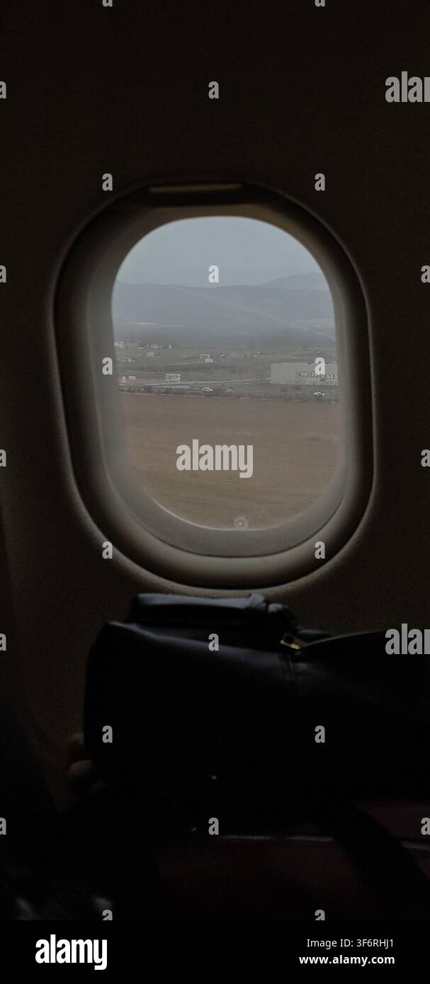 Cadres de fenêtre d'avion lors d'une approche à basse altitude sur des terres agricoles et des bâtiments industriels, offrant une vue pour les passagers quelques instants avant l'atterrissage. Palma de Mallor Banque D'Images