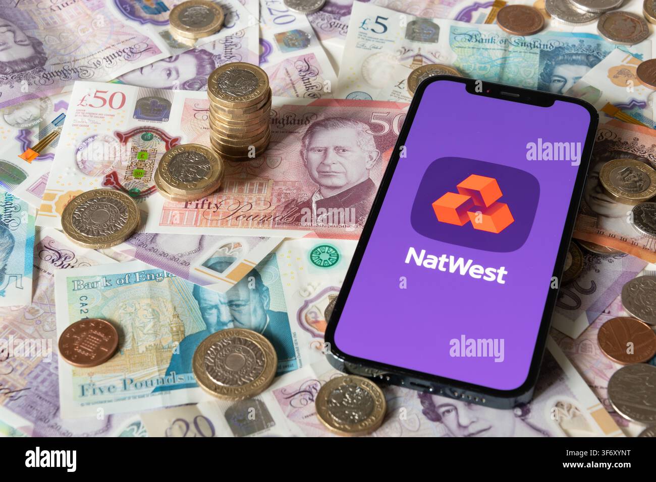 Application bancaire Nat West avec des billets et pièces en arrière-plan Banque D'Images