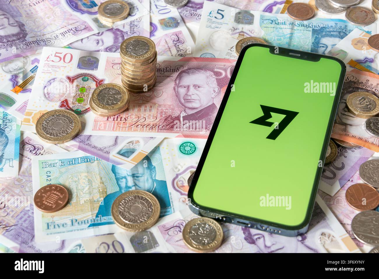 Application de transfert d'argent intelligente avec des billets et pièces en livres en arrière-plan Banque D'Images