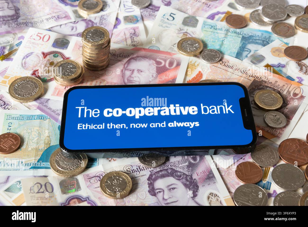 L'application bancaire de la banque coopérative (Coop) avec des billets et pièces en livres en arrière-plan Banque D'Images