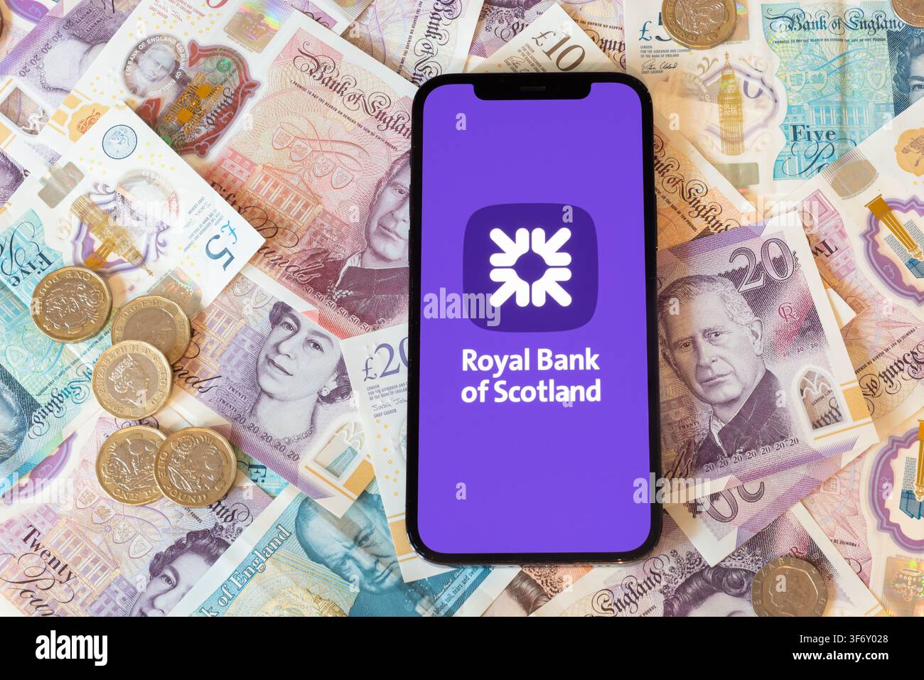 Application bancaire Bank of Scotland avec des billets et pièces en livres sterling en arrière-plan Banque D'Images