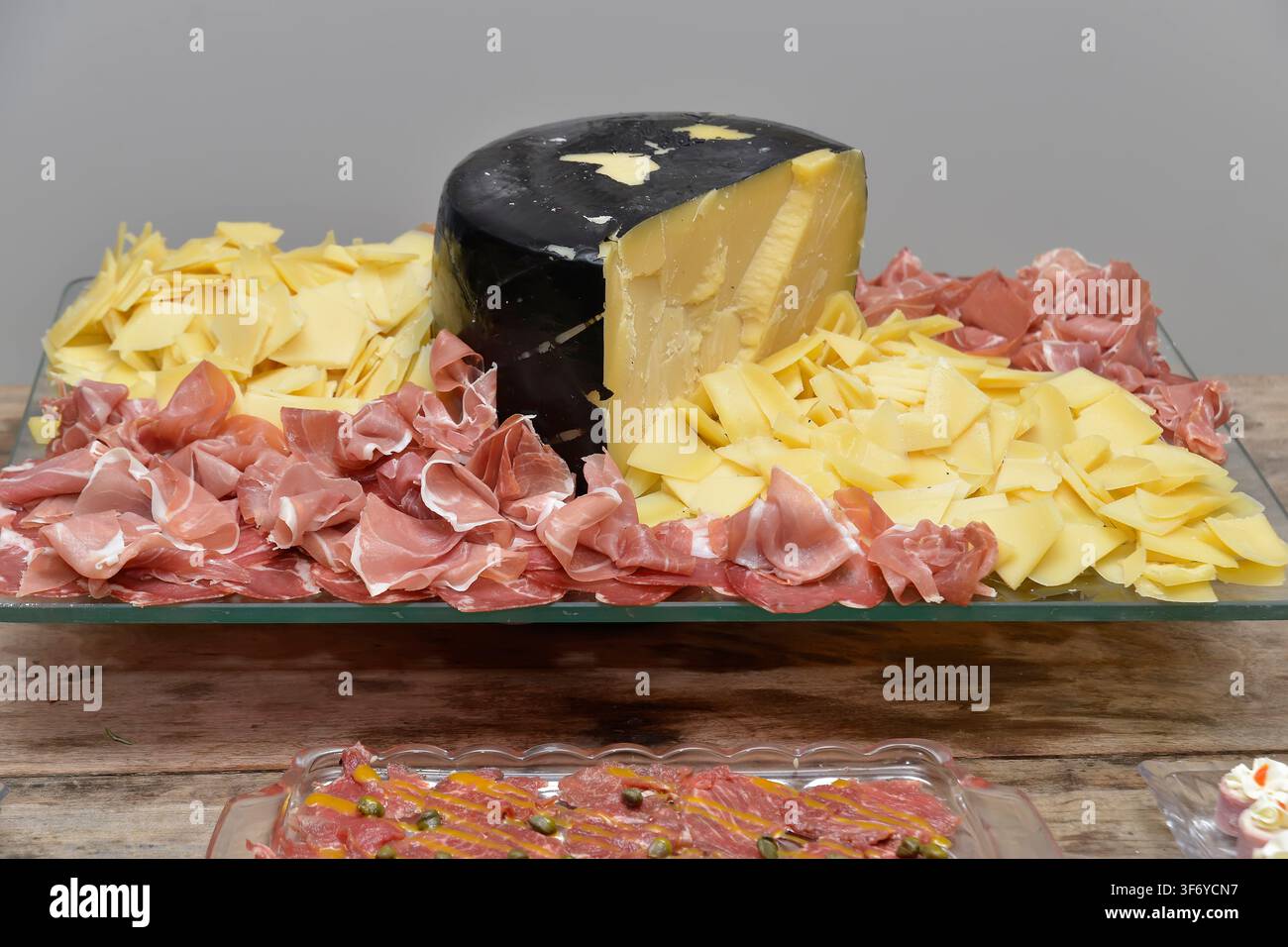 Planche à fromage artisanal à croûte noire avec jambon sec pour événements gastronomiques, buffets et fêtes Banque D'Images