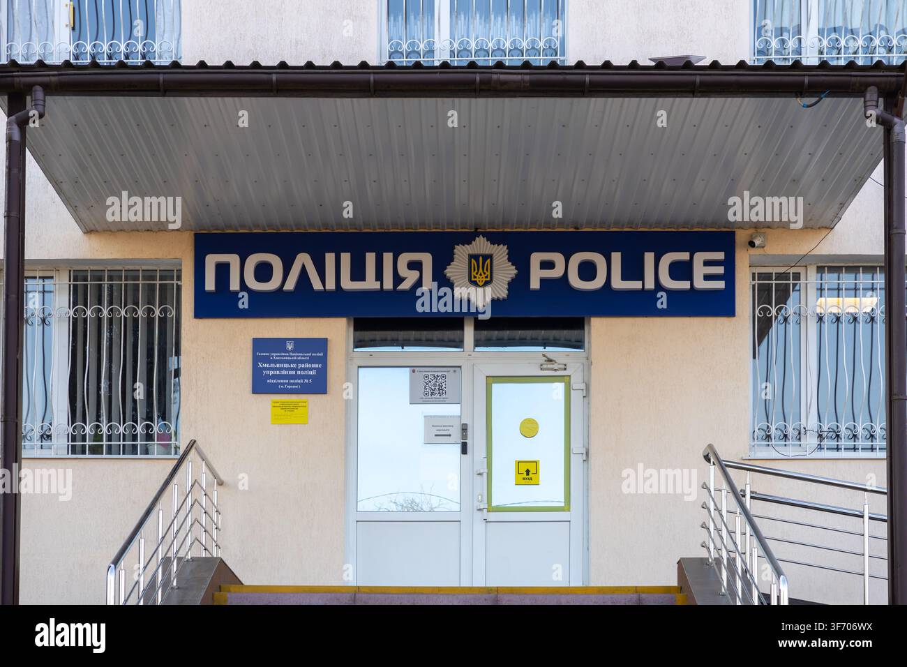 Horodok, Ukraine – 25 mars 2026 : Façade de bâtiment arborant un panneau bleu de poste de police au-dessus d'une porte d'entrée, représentant la sécurité officielle de l'État Banque D'Images