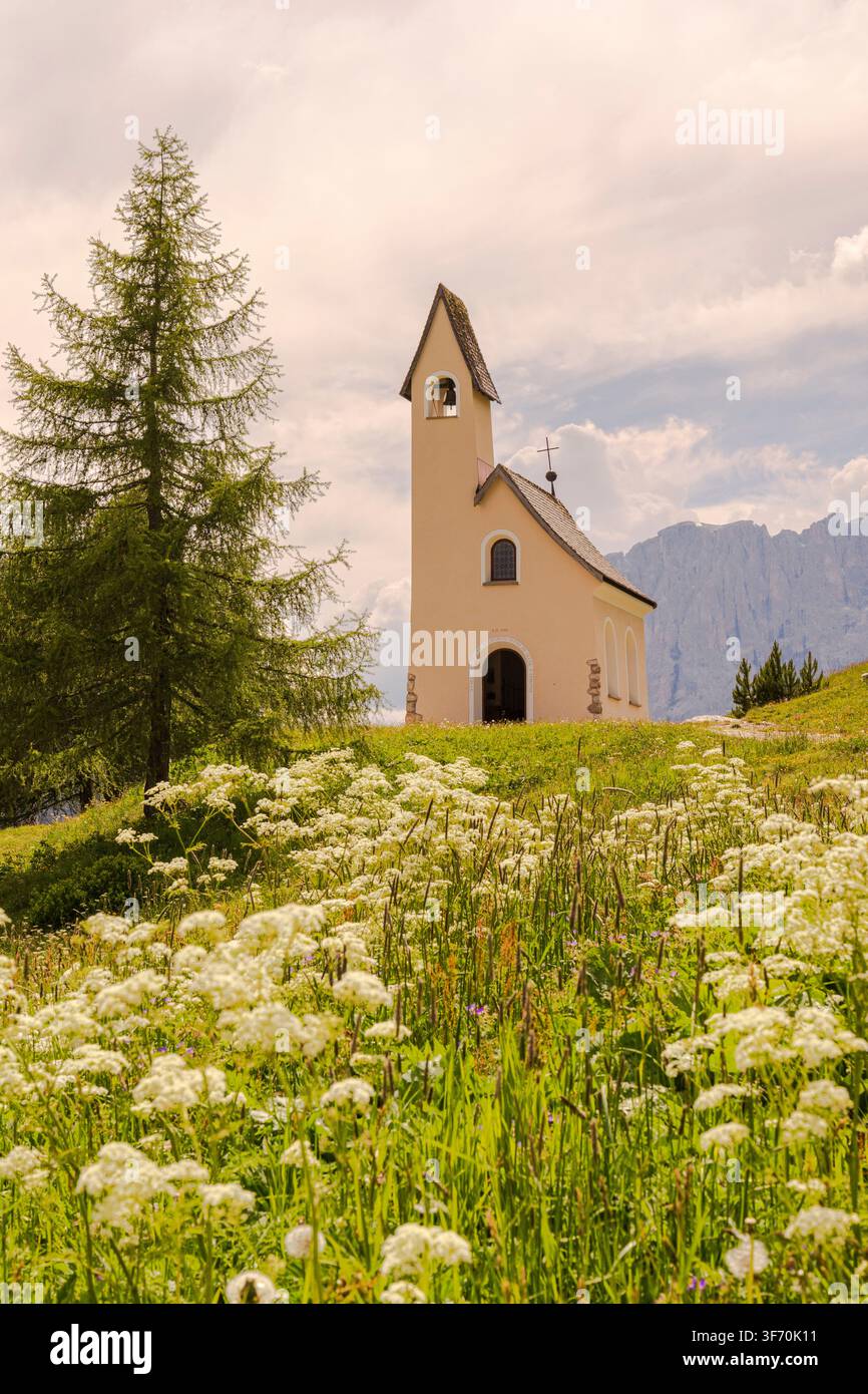 Chapelle de San Maurizio, Col de Gardena, Selva di Val Gardena, Italie. Une église entourée de fleurs du printemps et de l'été. Banque D'Images