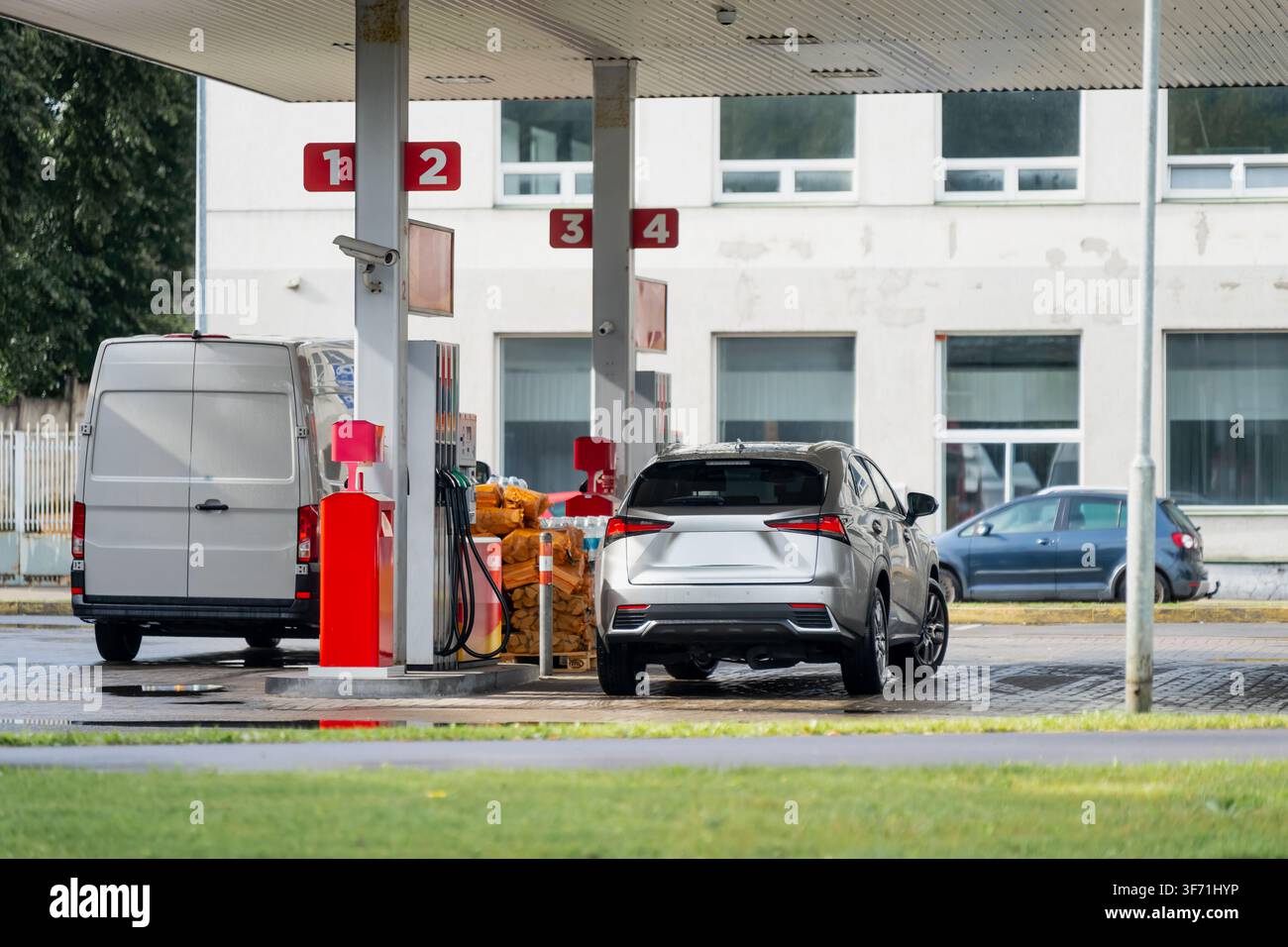 Ravitaillement des véhicules aux pompes à carburant d'une station-service représentant les coûts énergétiques croissants, les prix de l'essence, la logistique du pétrole et les dépenses automobiles Banque D'Images