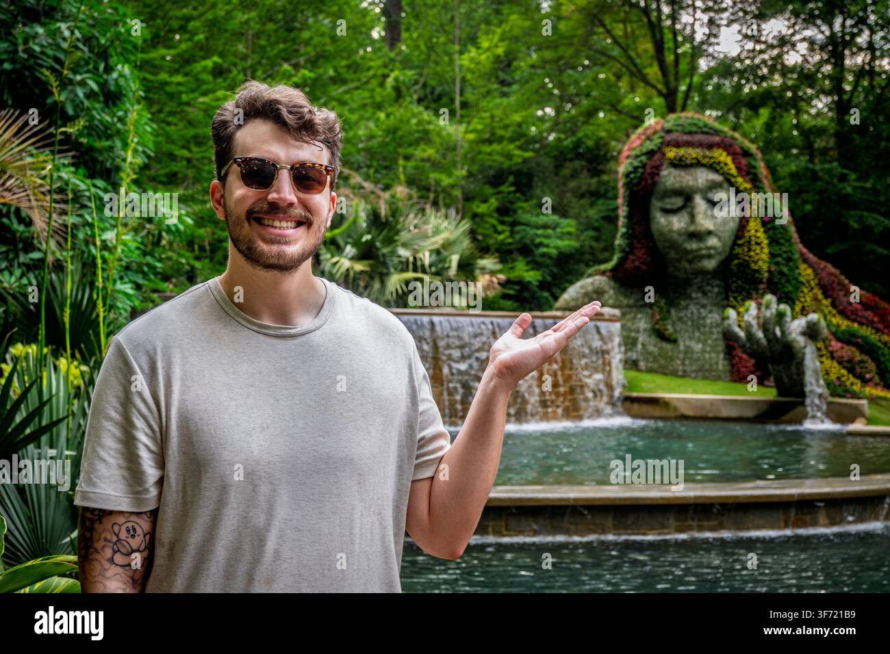 Atlanta, Géorgie - Mai 2026 : Un visiteur désigne la sculpture topiaire de la Déesse de la Terre au Jardin botanique d'Atlanta. Banque D'Images