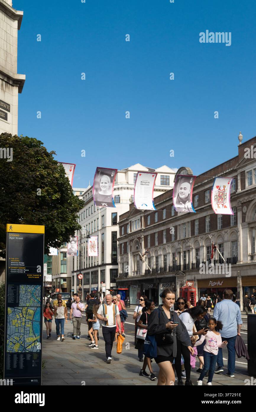Les piétons marchent sur The Strand à Londres sous les bannières "Kings & Queens", un projet d'art public rendant hommage aux travailleurs et résidents locaux. Banque D'Images