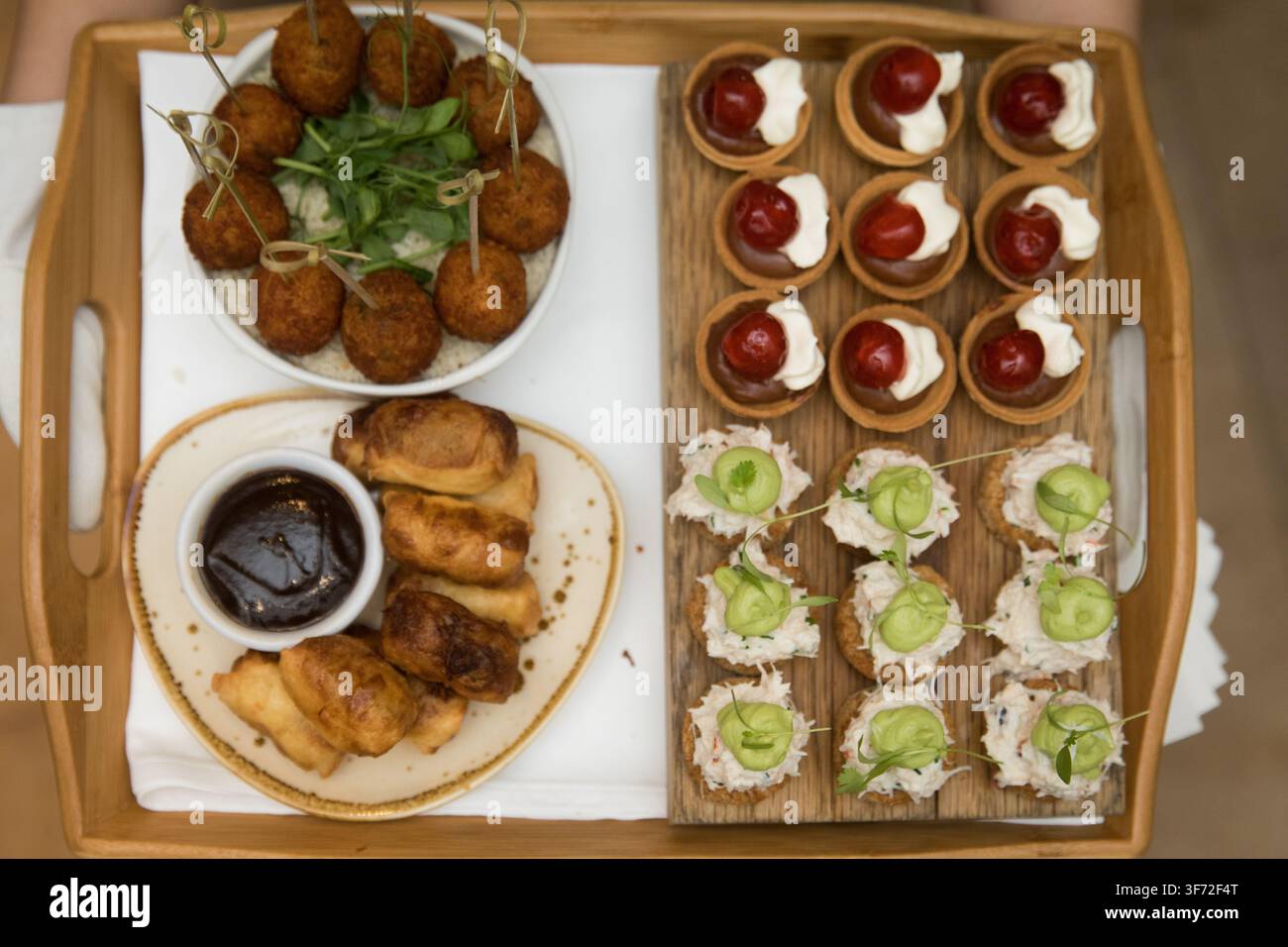 Les invités du Landmark London profitent d'une sélection de canapés salés et sucrés servis lors d'un thé de l'après-midi sophistiqué. Banque D'Images