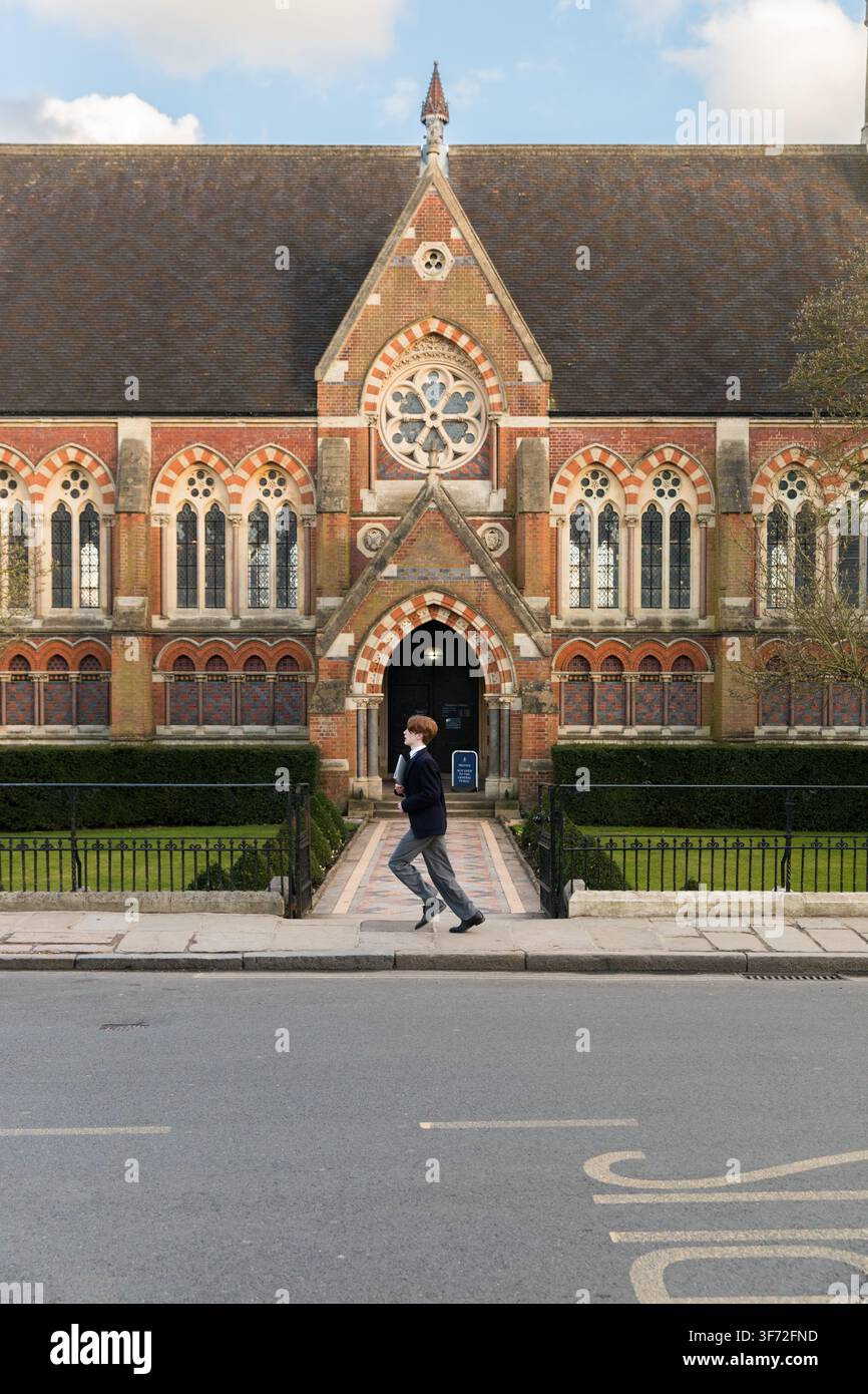 Un élève en uniforme court vers la bibliothèque Vaughan, se précipitant en classe à l'historique Harrow School sur la colline. Banque D'Images