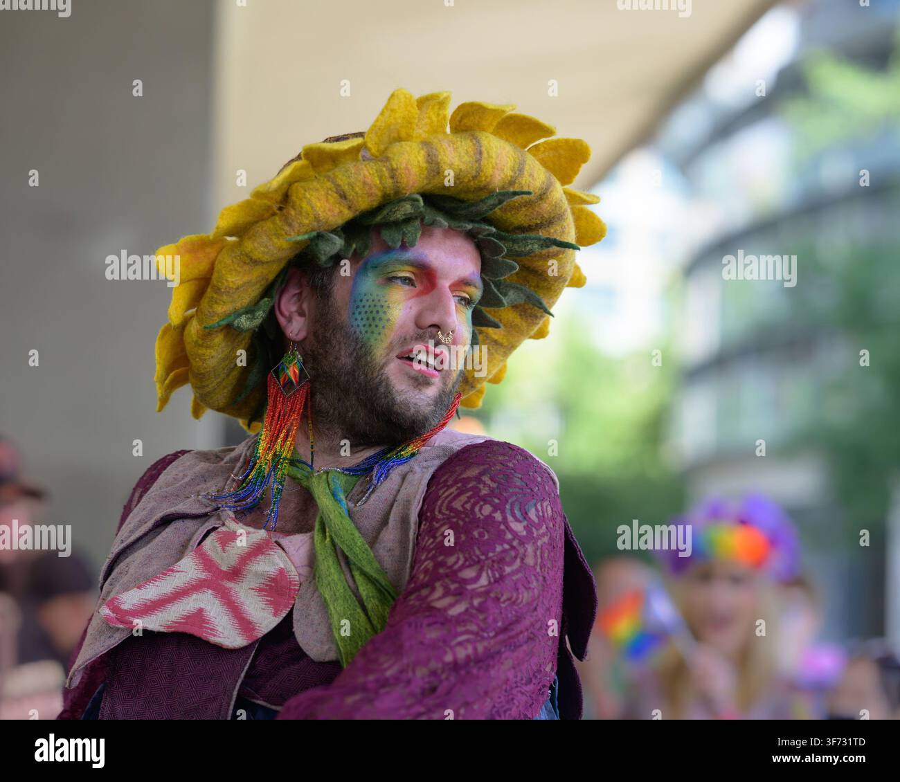 Jeune homme avec chapeau de tournesol, boucles d’oreilles, anneau nasal, vêtements colorés, Parade du Pride, Vancouver, Colombie-Britannique, Canada Banque D'Images
