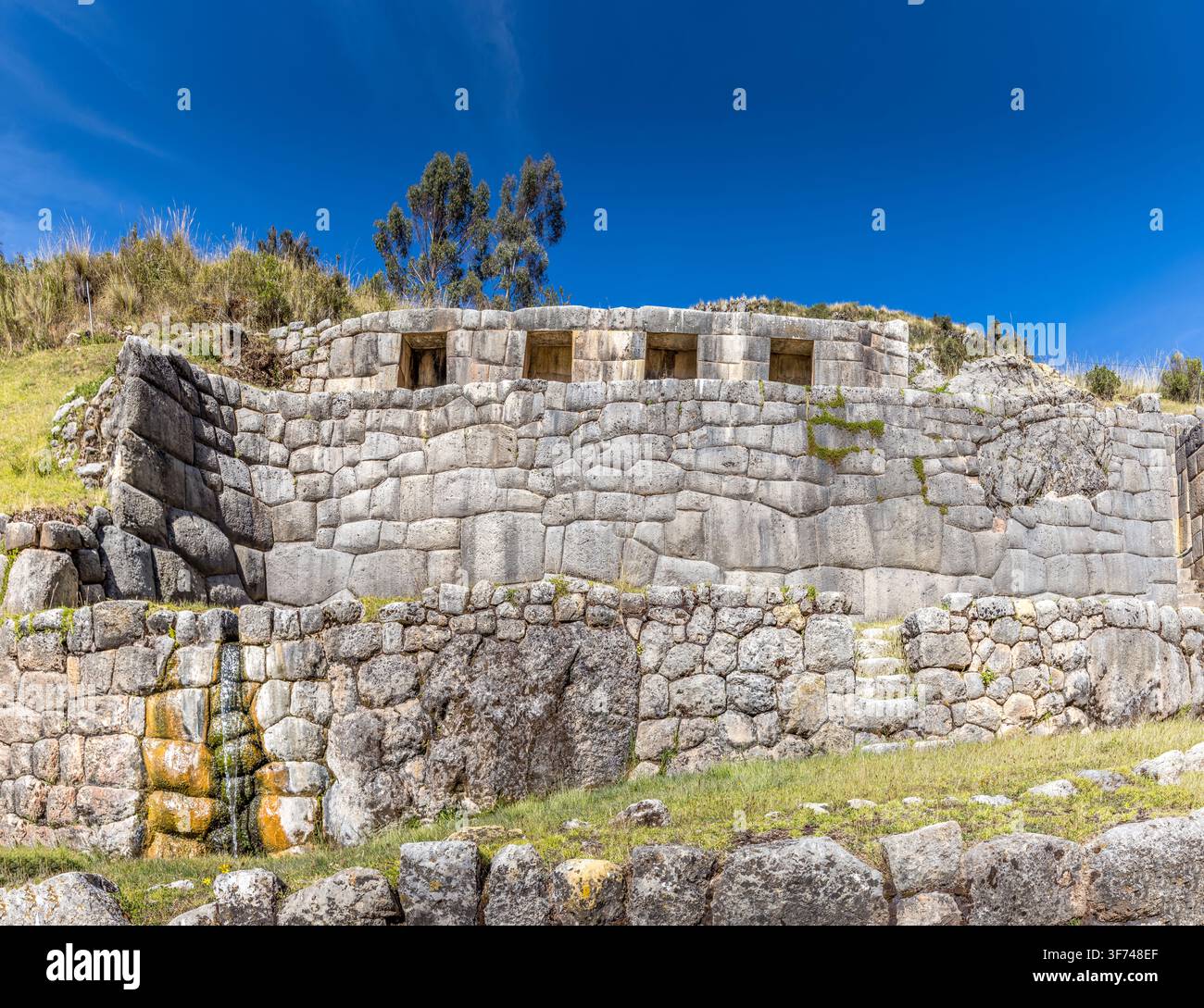 Ancienne forteresse inca de Puka Pukara avec des murs de pierre finement travaillés nichés dans les hautes terres andines sous un ciel bleu clair Banque D'Images