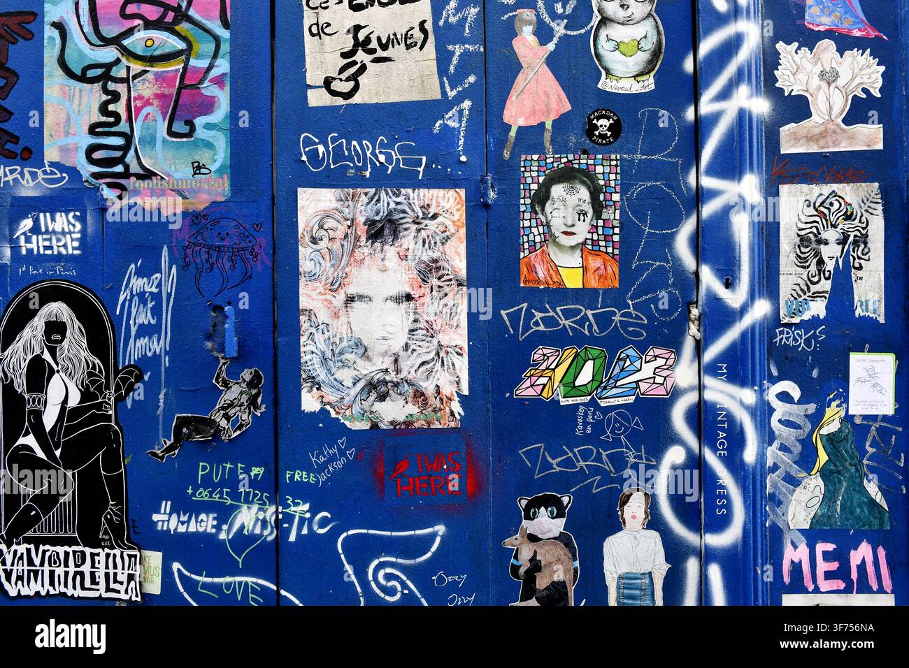 Porte ou volet métallique bleu recouvert d'une collage urbaine de divers arts de rue, tags de graffitis et autocollants collés à Montmartre - Paris - France Banque D'Images