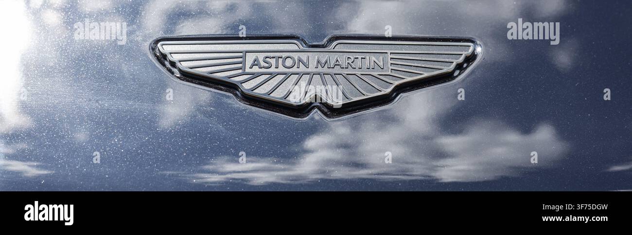 Ljubljana, Slovénie - 25 juin 2026 : Le logo Aston Martin se dresse sous un soleil éclatant, mettant en valeur ses lignes fluides et son design luxueux. Banque D'Images