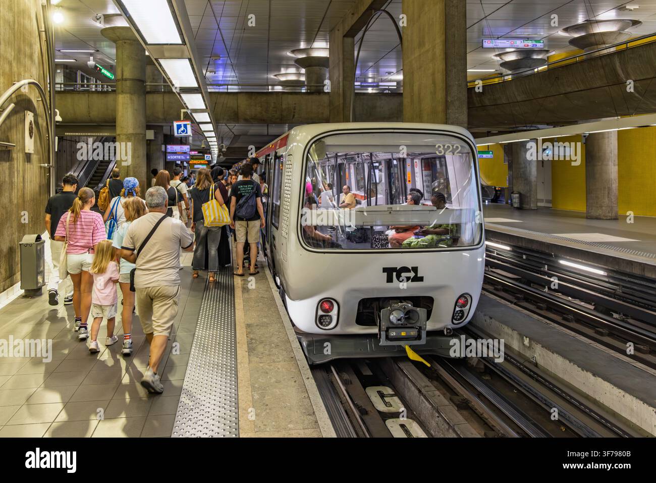 Lyon, France - 27 juillet 2026 : Des personnes attendant et montant dans un métro automatisé sans conducteur exploité par TCL sur une plateforme souterraine. Banque D'Images