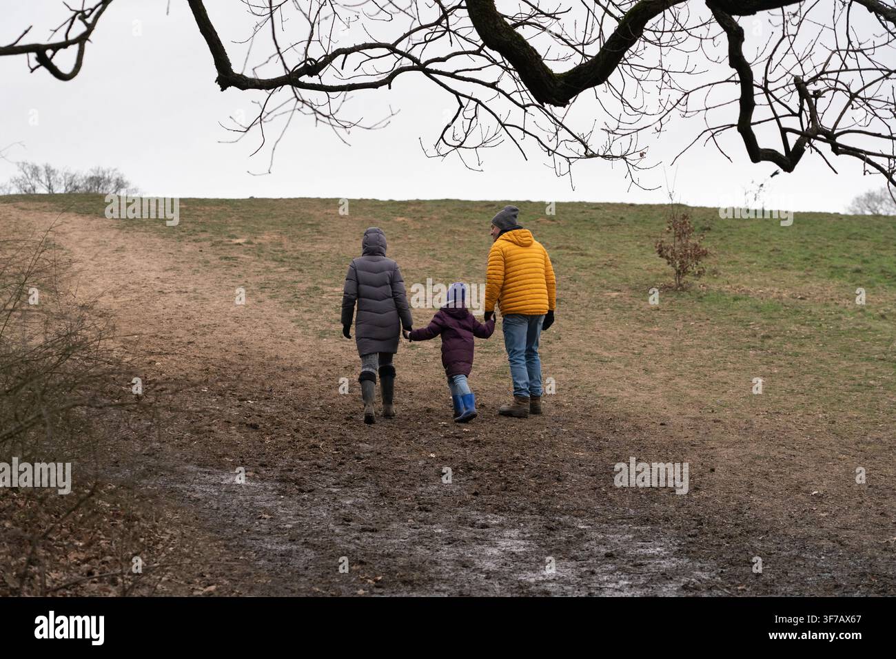 Une famille profite d'une promenade boueuse sur Parliament Hill à Hampstead Heath, partant pour leur exercice quotidien en plein air. Banque D'Images