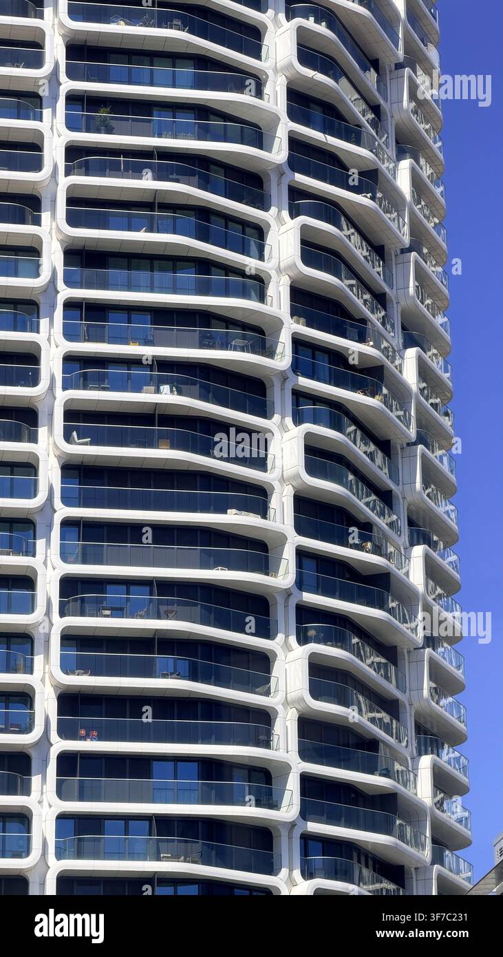Bâtiment résidentiel moderne à Francfort, en Allemagne, présentant des balcons incurvés répétitifs et des rampes en verre contre un ciel bleu clair. - Image de stock capturée avec un smartphone