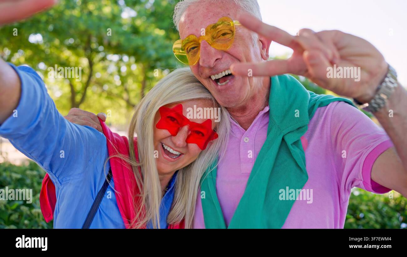 Couple de personnes âgées profitant d'un selfie amusant avec un signe de paix ou un signe V Banque D'Images