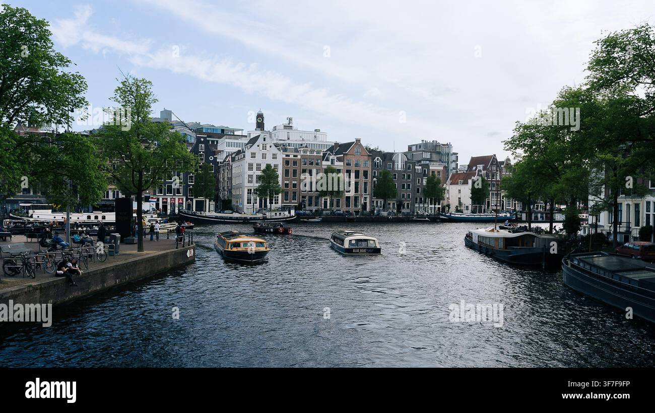 Vue panoramique sur un canal avec une architecture néerlandaise traditionnelle et des bateaux dans le centre historique d'Amsterdam, Pays-Bas Banque D'Images