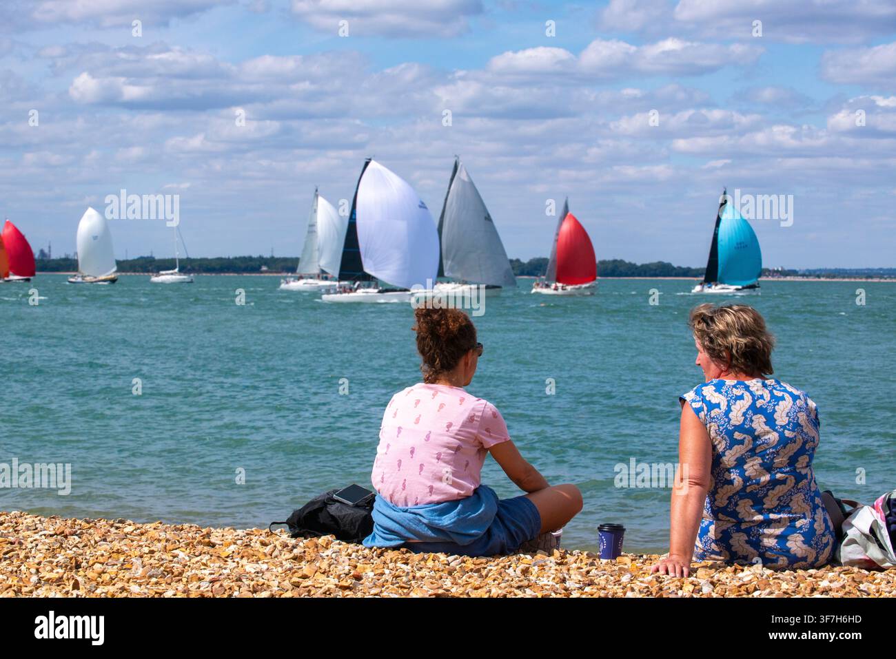North Sails Cowes Week 2026 — flotte mixte naviguant vers la ligne d'arrivée de la Royal Squadron, passant devant le cargo Grimaldi qui vient de partir Banque D'Images