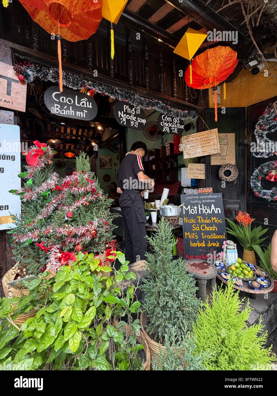 La joie de Noël rencontre la tradition locale au stand de thé aux herbes le plus emblématique de Hoi An. - Image de stock capturée avec un smartphone