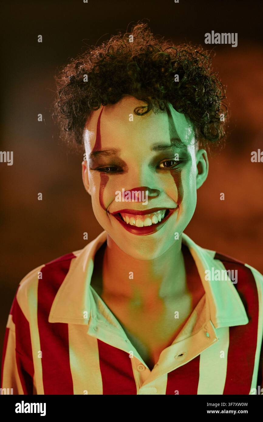 Portrait d'un enfant souriant en maquillage de clown célébrant Halloween Banque D'Images