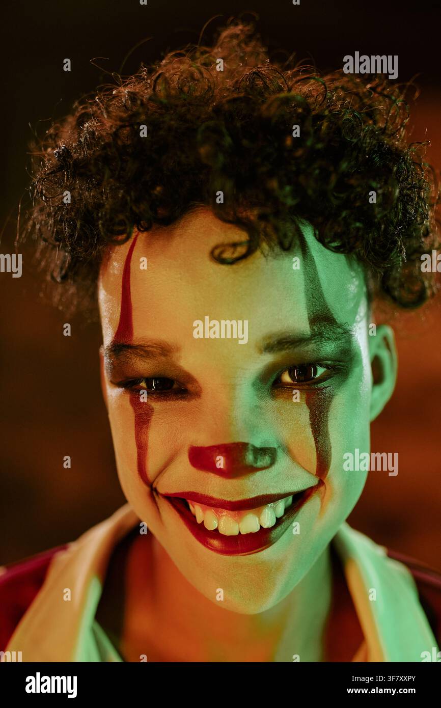Portrait d'un enfant souriant portant un maquillage de clown effrayant pour Halloween Banque D'Images