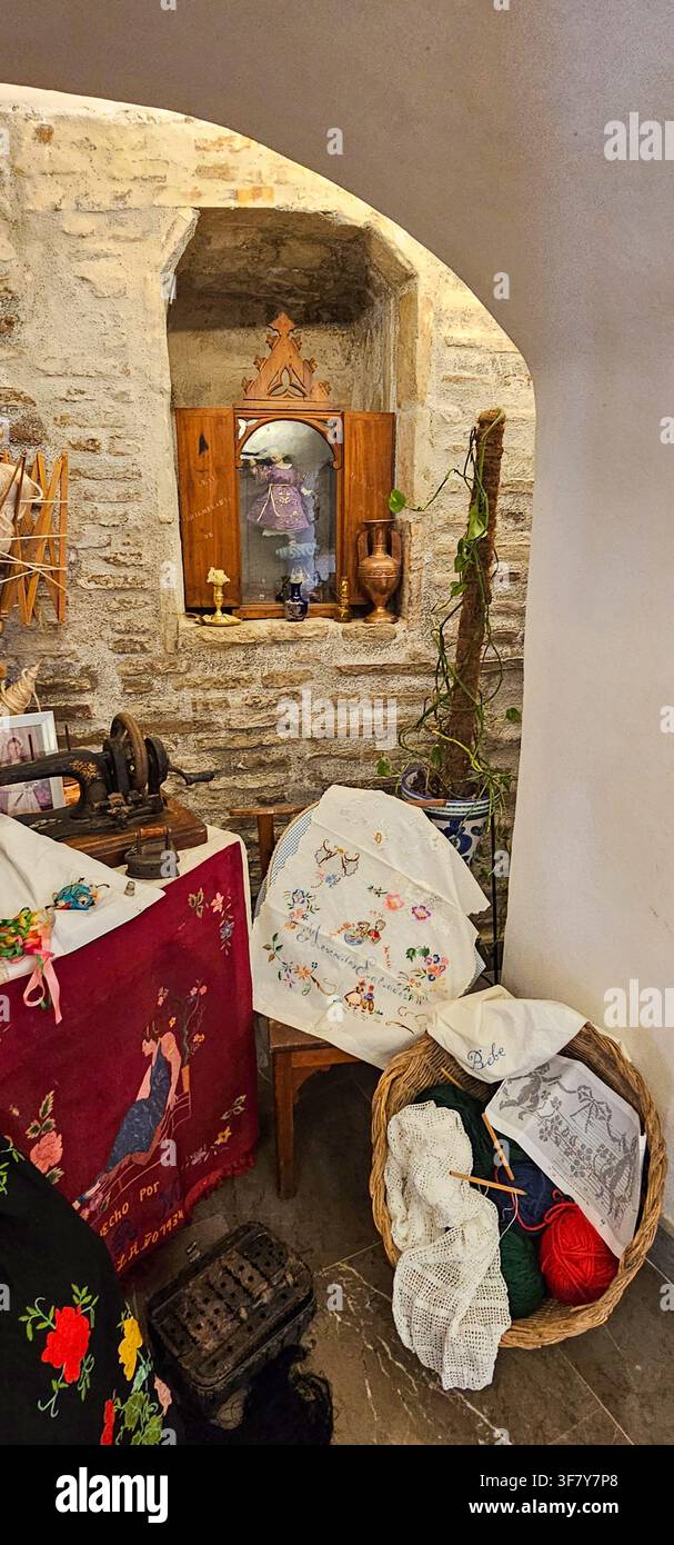 Présentation traditionnelle de broderie et de travaux d'aiguille avec des fournitures de couture, du crochet, du fil, une machine à coudre vintage et des objets ménagers disposés dans un b Banque D'Images