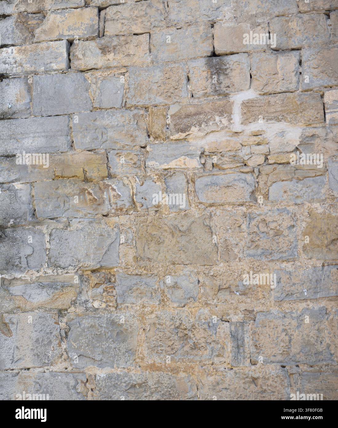 Mur de pierre de la façade d'un ancien bâtiment dégradé par le temps. Vue de face. Banque D'Images