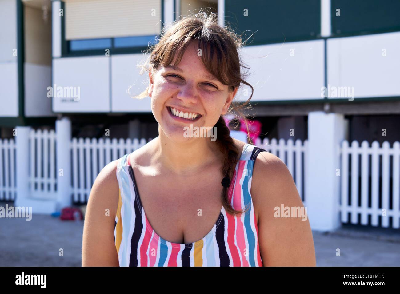 Femme joyeuse regardant l'appareil photo et souriant à la plage. Banque D'Images