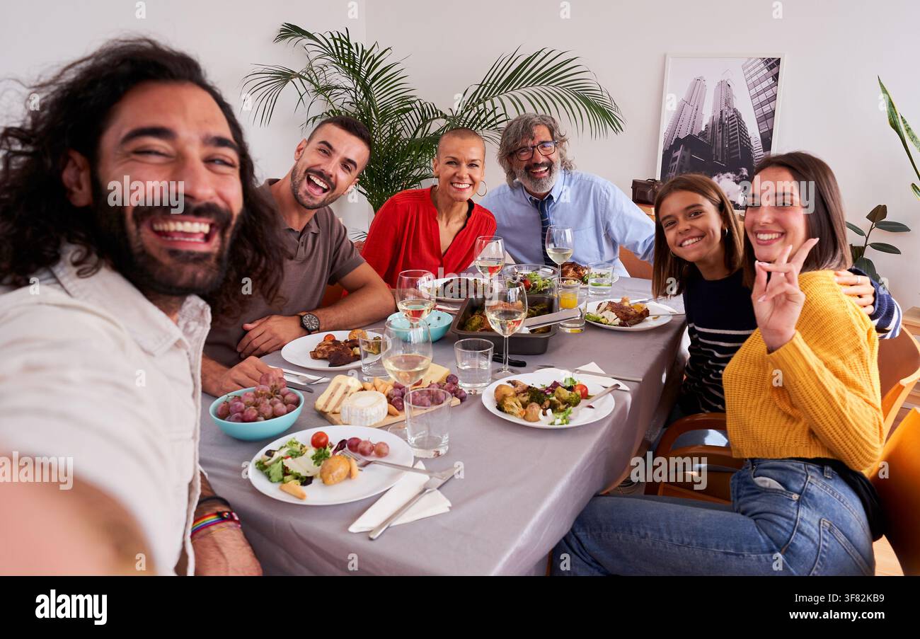 Selfie d'amis et de famille profitant d'un repas ensemble à la maison. Banque D'Images
