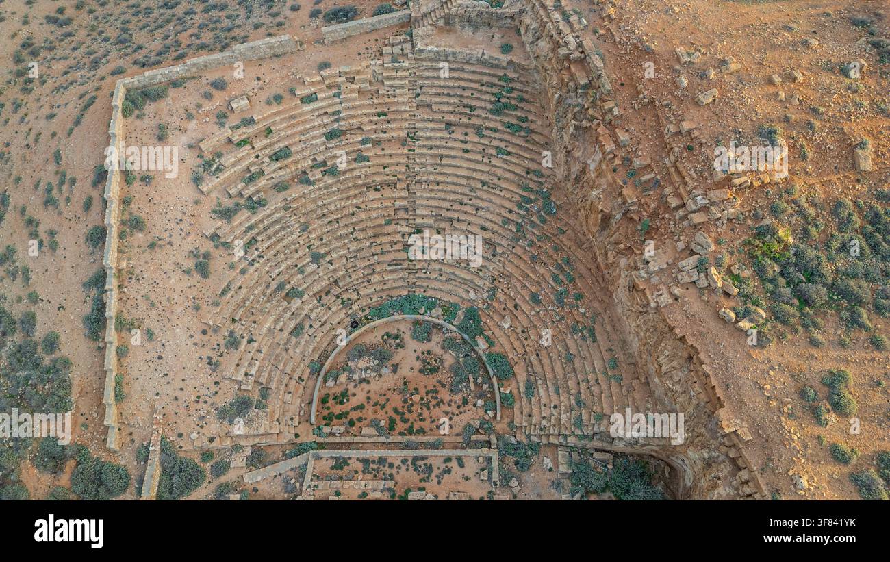 Ruines d'un théâtre grec antique avec des gradins en pierre et de la végétation dans la vieille ville d'Apollonia située dans l'est de la Libye Banque D'Images
