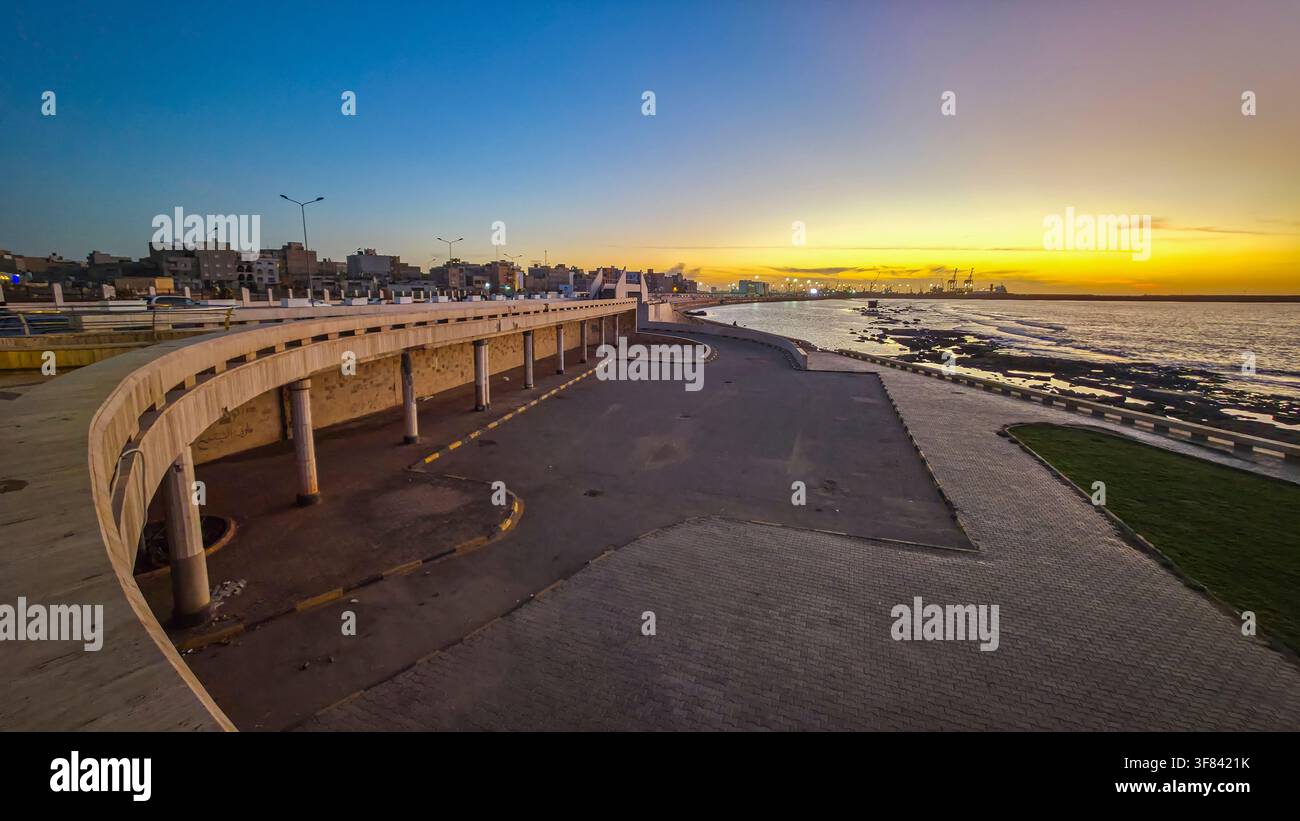 Couchant le long du front de mer à Benghazi, Libye avec l'horizon urbain visible en arrière-plan Banque D'Images