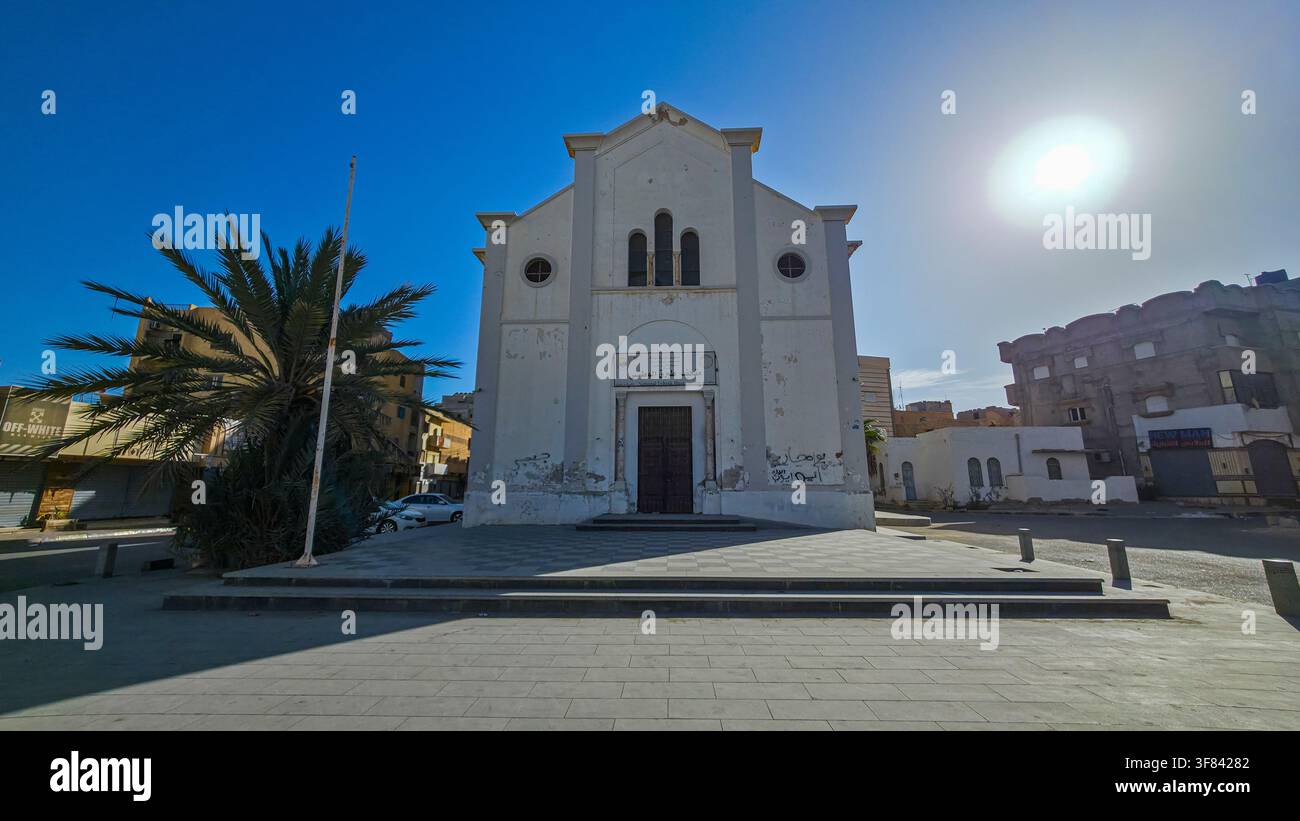 Ancienne église se dressant à Tobrouk entourée de bâtiments modernes et d'un ciel lumineux en Éthiopie Banque D'Images
