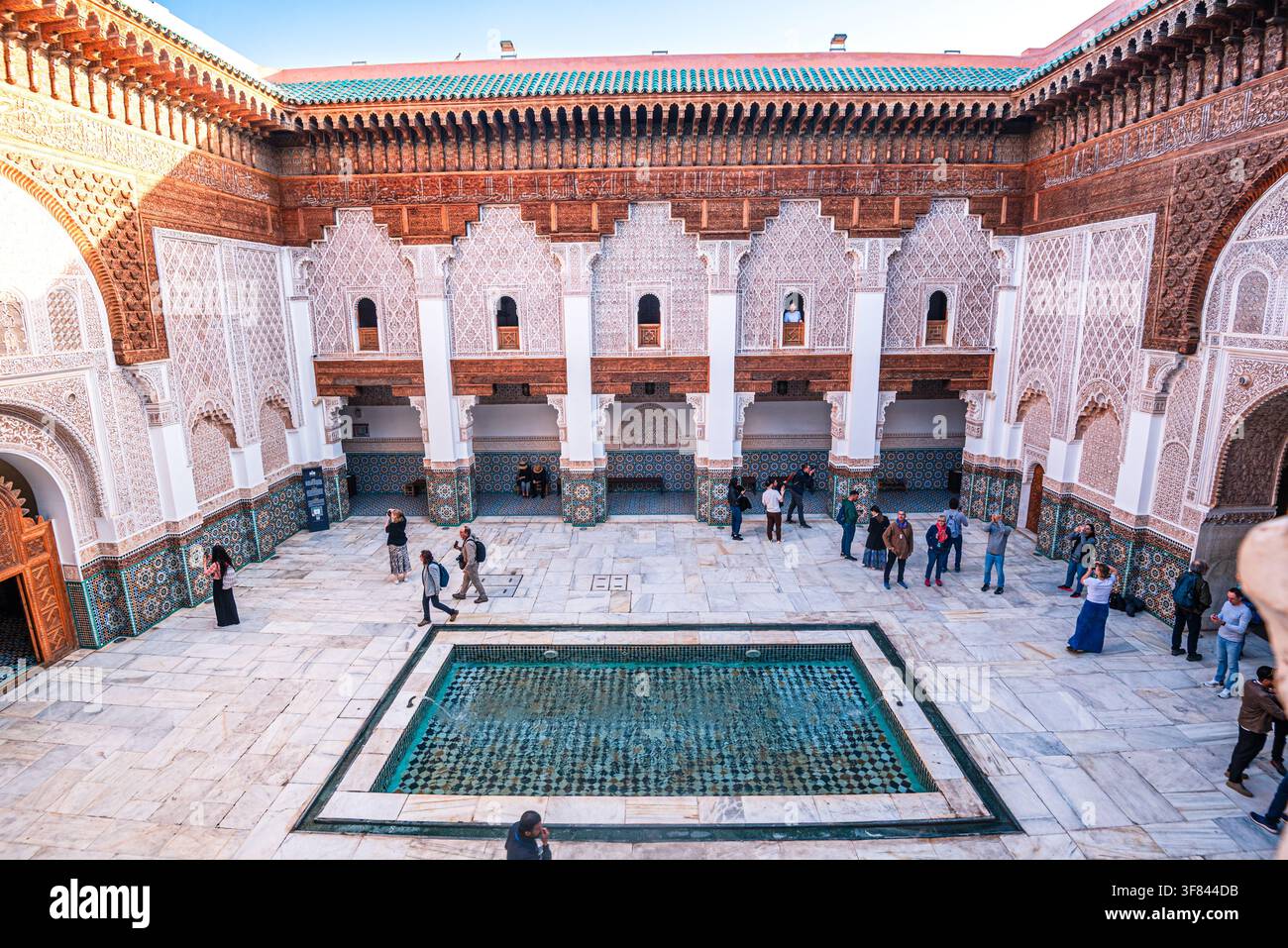 Exploration de la cour de la Madrasa Ben Youssef à Marrakech avec des carreaux zellij et une piscine réfléchissante Banque D'Images