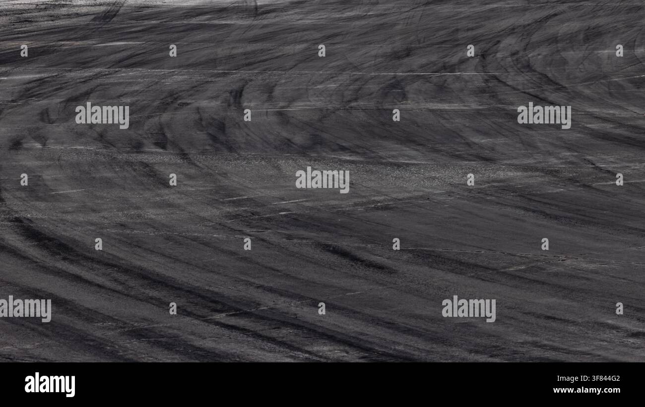 fond de route asphaltique abstrait avec des traces de pneus noires sur la piste de course, texture et fond automobile et traces de dérapage de pneus Banque D'Images
