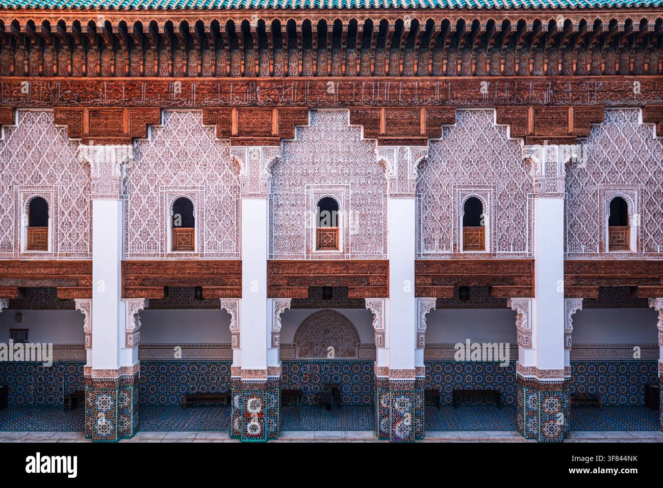 Exploration de la galerie supérieure de la médersa Ben Youssef avec des reliefs en stuc et des carreaux zellij à Marrakesh Banque D'Images