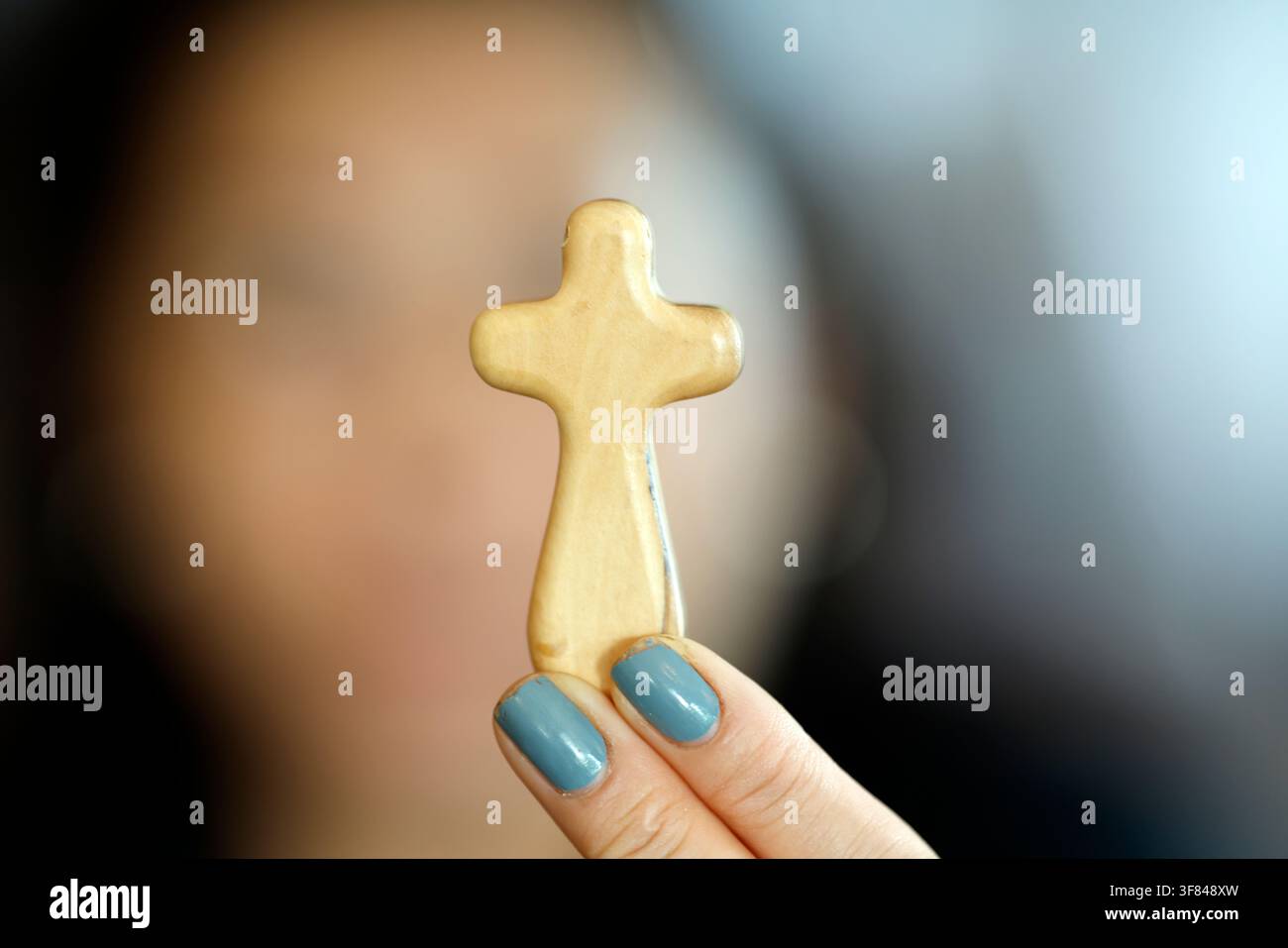 Une femme catholique tient une croix en bois d'olive pendant un moment de prière au Vietnam Banque D'Images