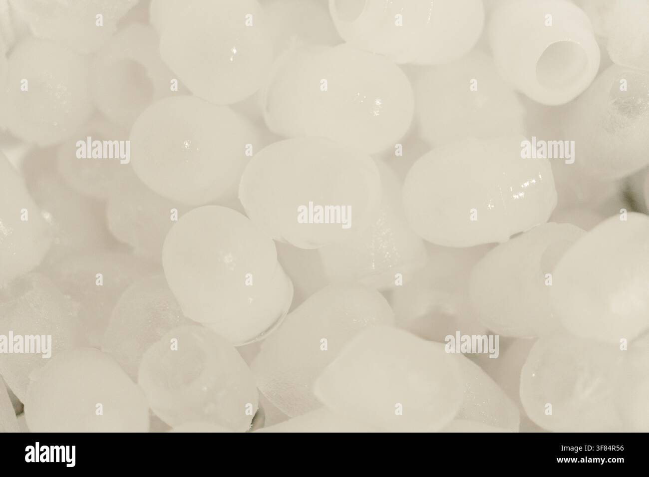 Bouchons de glace ronds stockés dans un récipient en plastique prêt pour les boissons froides. Gros plan de la texture de la glace congelée pour la préparation des boissons. Banque D'Images