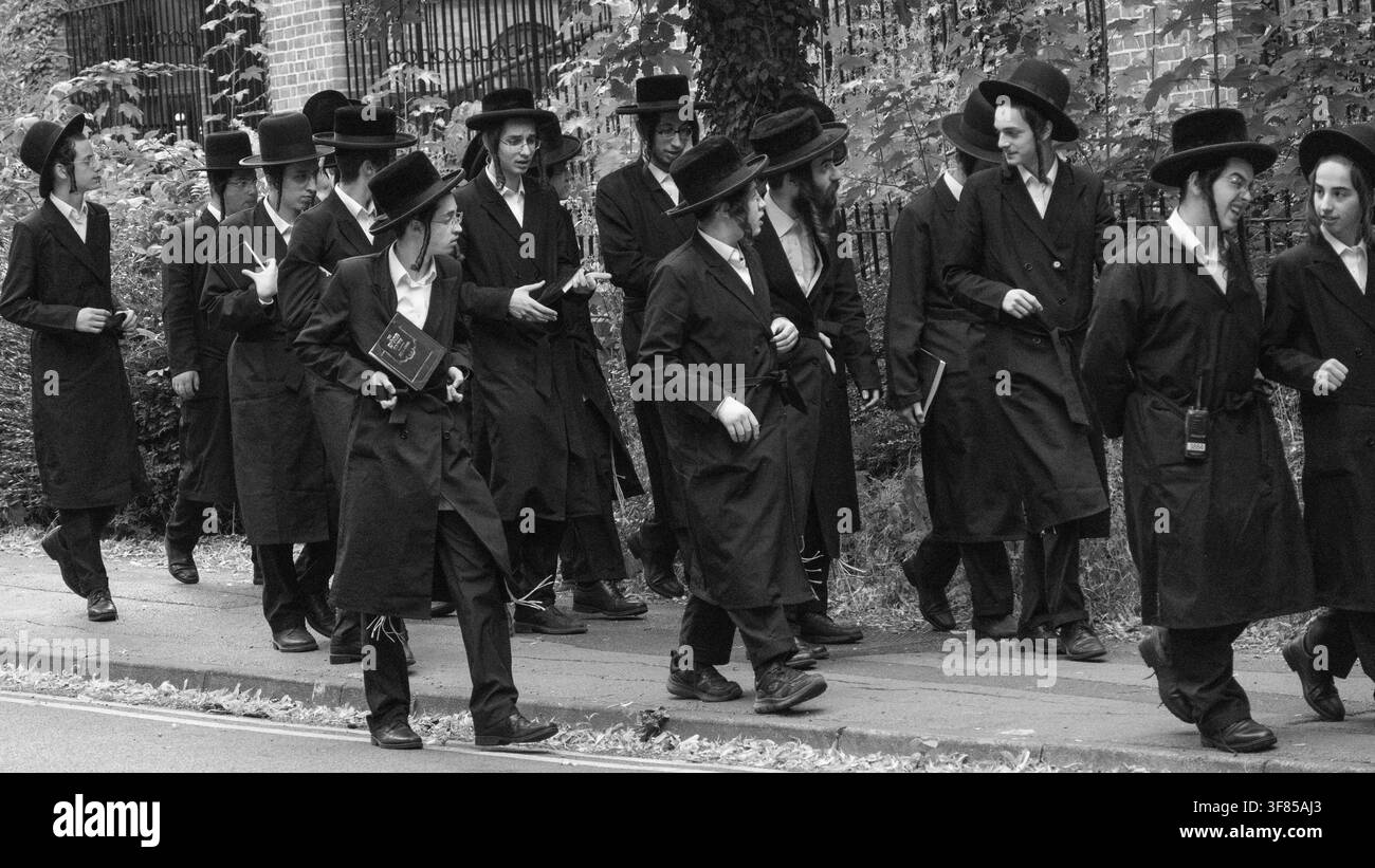 Jeunes hommes juifs orthodoxes marchant ensemble à travers York, North Yorkshire, Angleterre, Royaume-Uni, portant une tenue religieuse traditionnelle. Banque D'Images