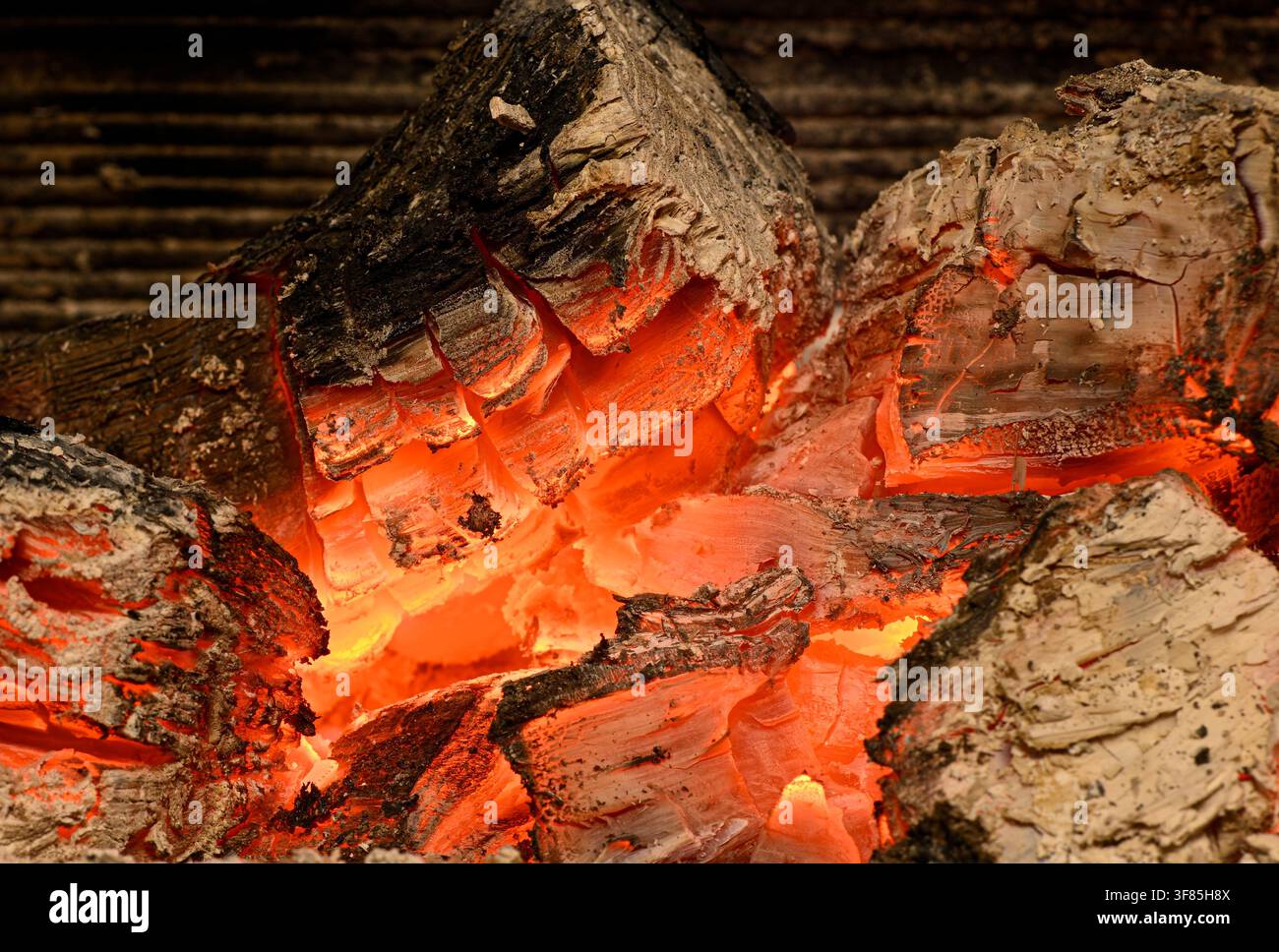 Braises d'une cheminée lumineuses révélant la chaleur et la texture dans une vue rapprochée vive Banque D'Images