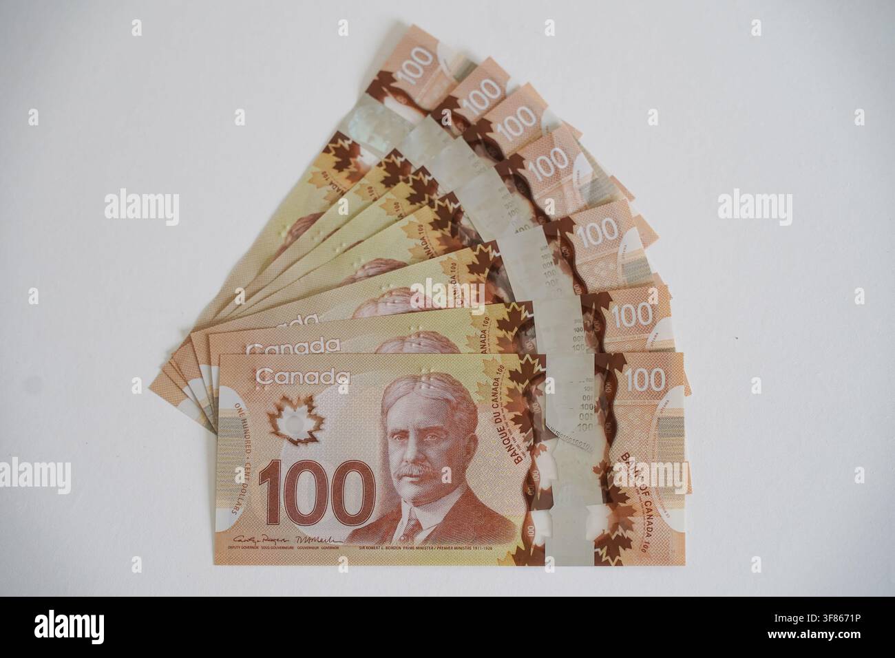 Arrangement en éventail de cent billets de banque en papier canadiens disposés sur une surface légère. Banque D'Images