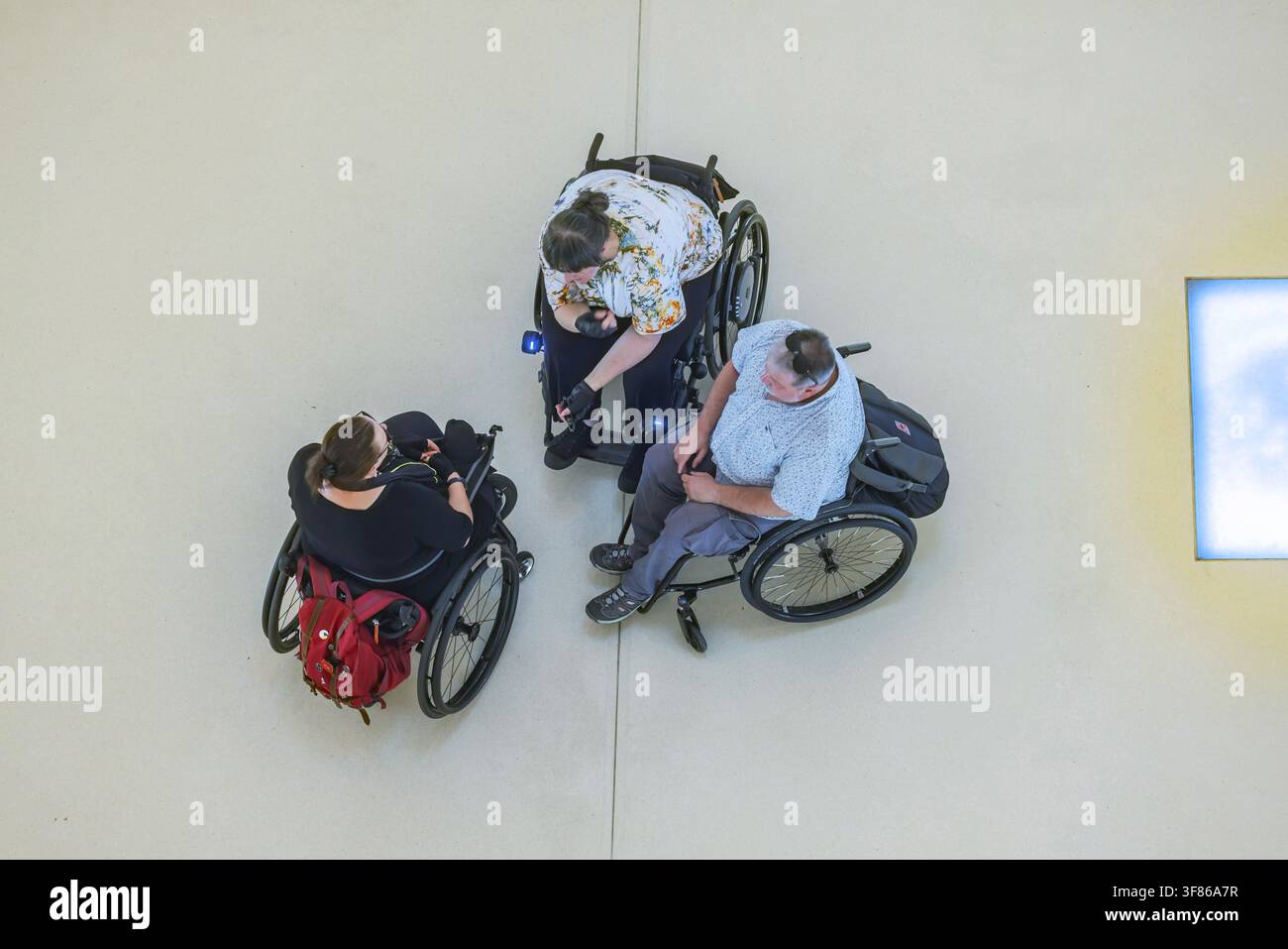 Trois utilisateurs de fauteuils roulants à l'intérieur de la Bibliothèque Municipale de Stuttgart. Vue par-dessus. Stuttgart, Bade-Wurtemberg, Allemagne Banque D'Images