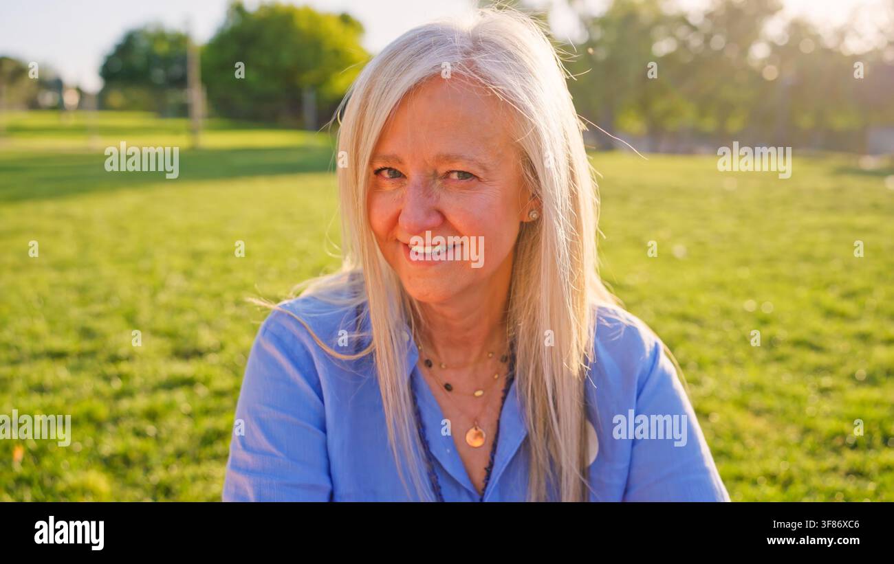 Sénior souriant dans un parc vert ensoleillé Banque D'Images
