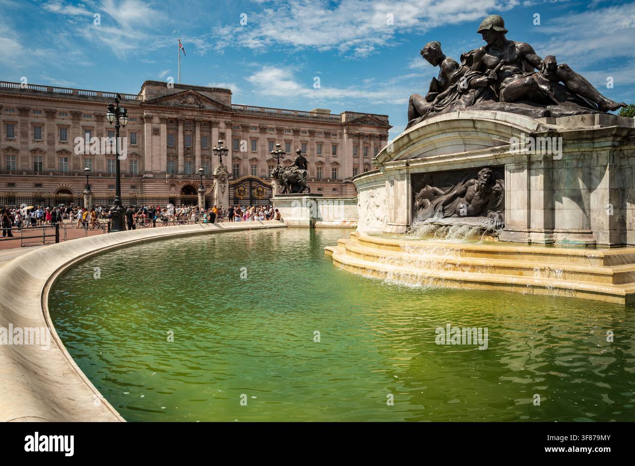 Fontaine commémorative Victoria avec le Palais de Buckingham et des foules de visiteurs à Londres sous un ciel d'été bleu. Banque D'Images